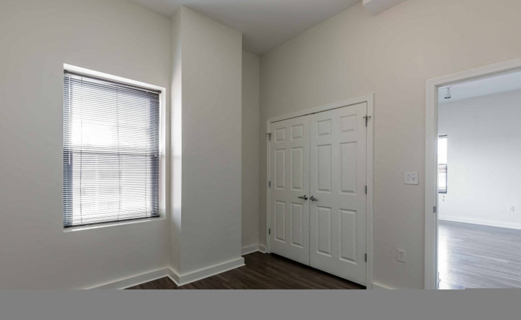 an empty bedroom with a door and a window
