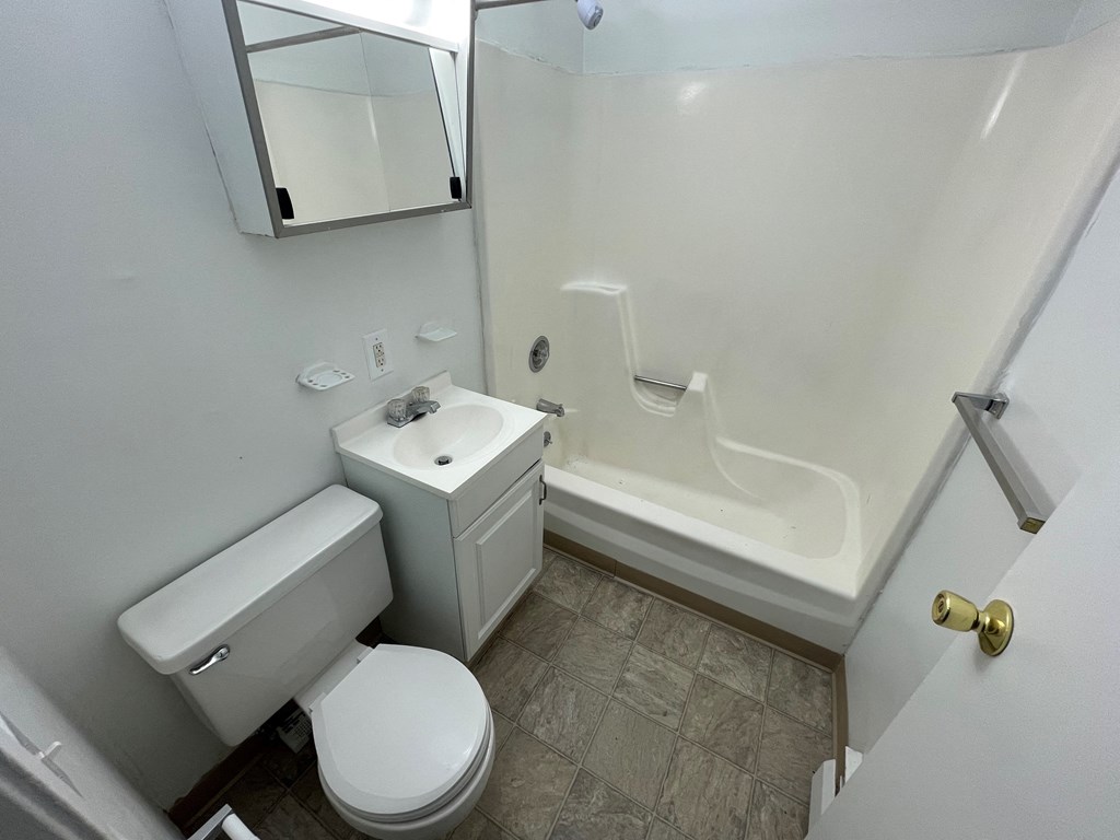 an empty bathroom with a toilet sink and shower