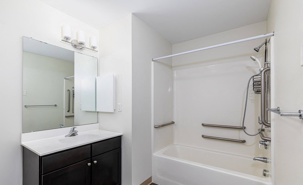 a bathroom with a shower and a sink and a mirror