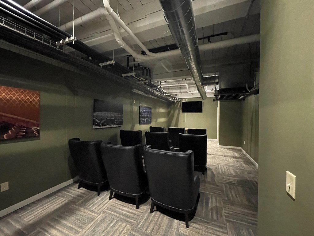 a group of black chairs in a room with green walls and a projector