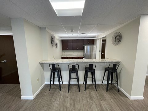 a kitchen with a bar and three stools in front of a kitchen counter top