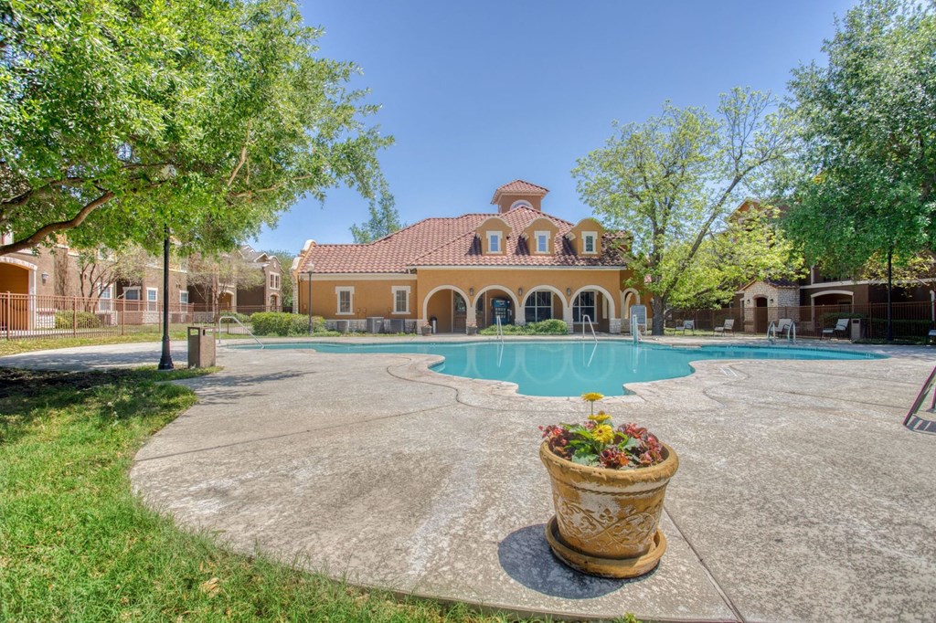 a large swimming pool with a house in the background