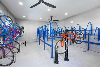 a room filled with bikes on racks and a ceiling fan at 55 Fifty at Northwest Crossing, Houston