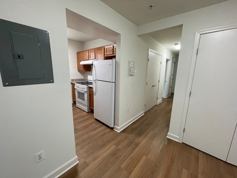 a renovated kitchen with white appliances and wood floors