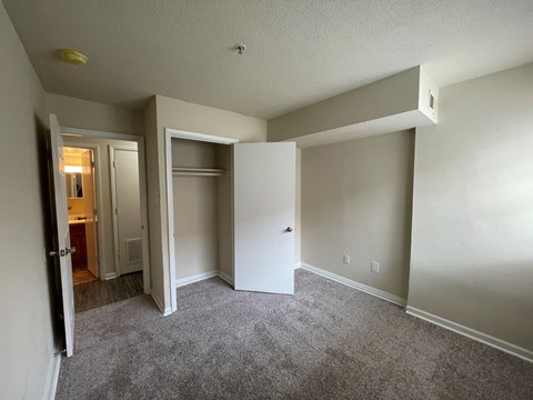 an empty living room with an open door to a closet