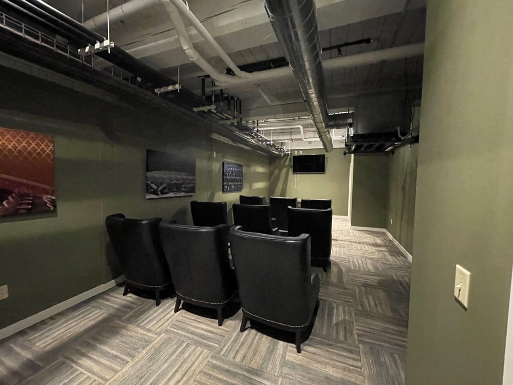 a conference room with black leather chairs and a green wall
