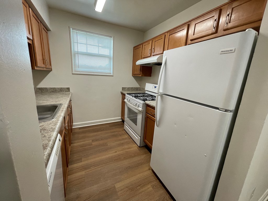 a kitchen with wood floors and white appliances