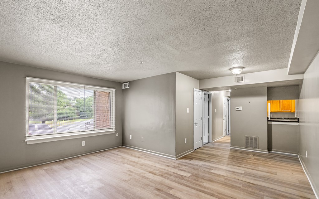 A room with a window and wooden floors.