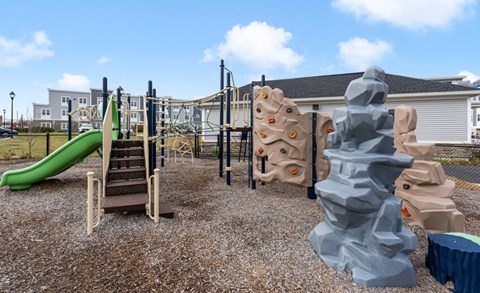 A playground with a green slide and climbing structures.