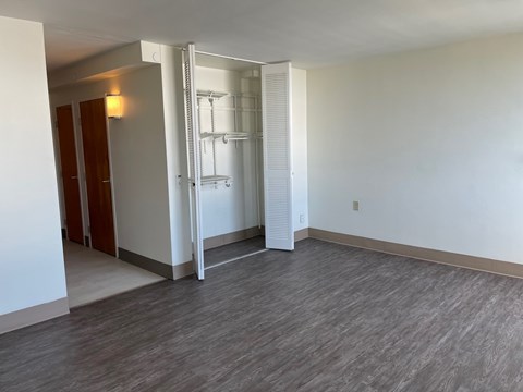 A room with a white wall and a wooden floor.