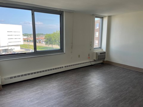 A room with a window overlooking a parking lot.
