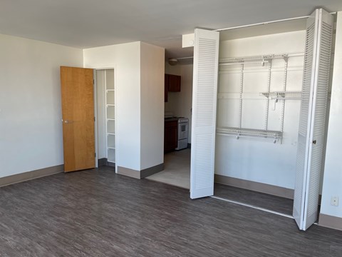A room with a wooden door and a white wall.