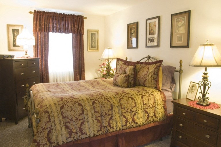 a bedroom with a bed and a dresser and a window