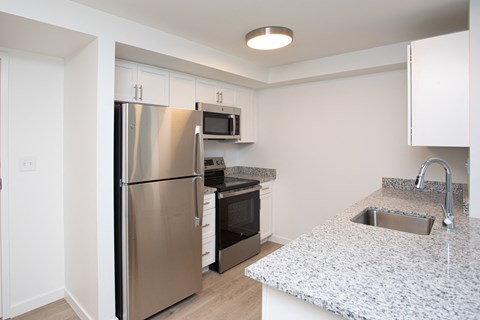 A kitchen with a stainless steel refrigerator, microwave, oven, and sink. A kitchen with a stainless steel refrigerator, microwave, oven, and sink.at The Camelot, West Hartford, CT 06119