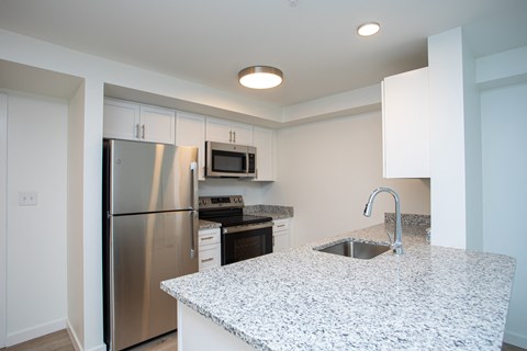 A kitchen with a granite countertop and stainless steel appliances. A kitchen with a granite countertop and stainless steel appliances.at The Camelot, West Hartford