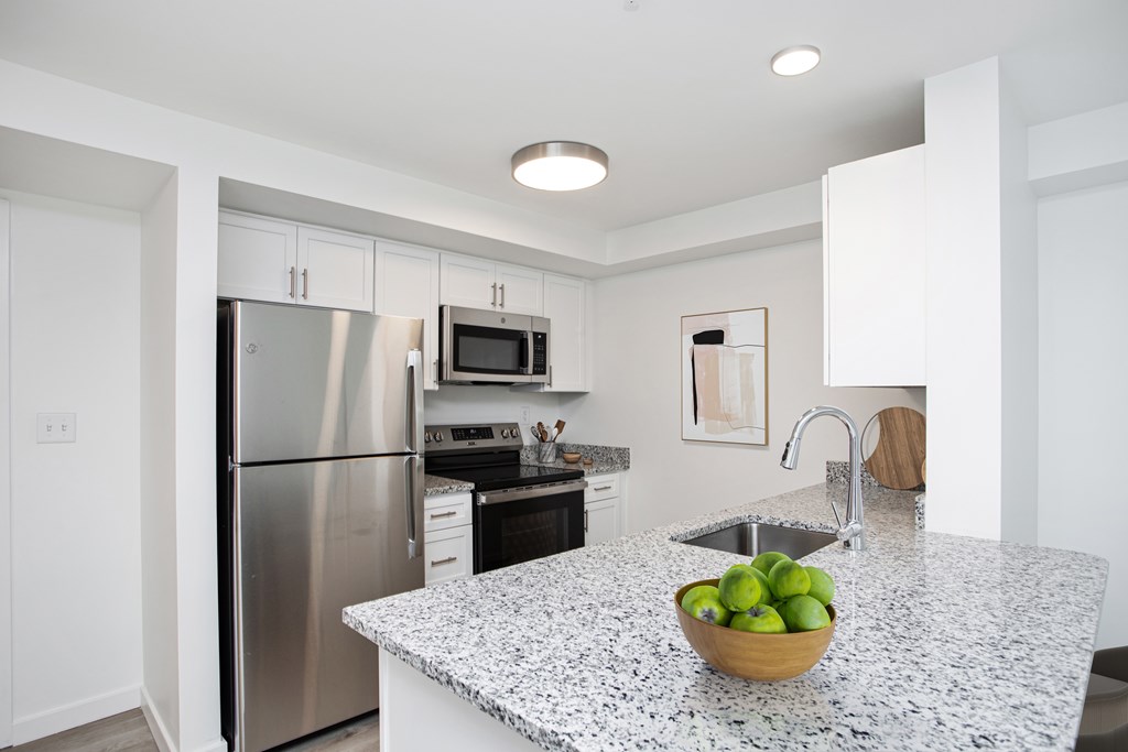 A kitchen with granite countertops and stainless steel appliances.