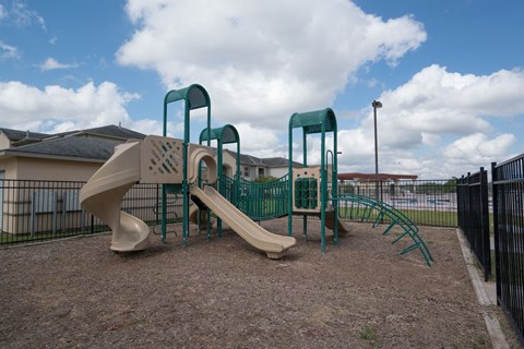 a playground with a slide and climbing equipment in a yard