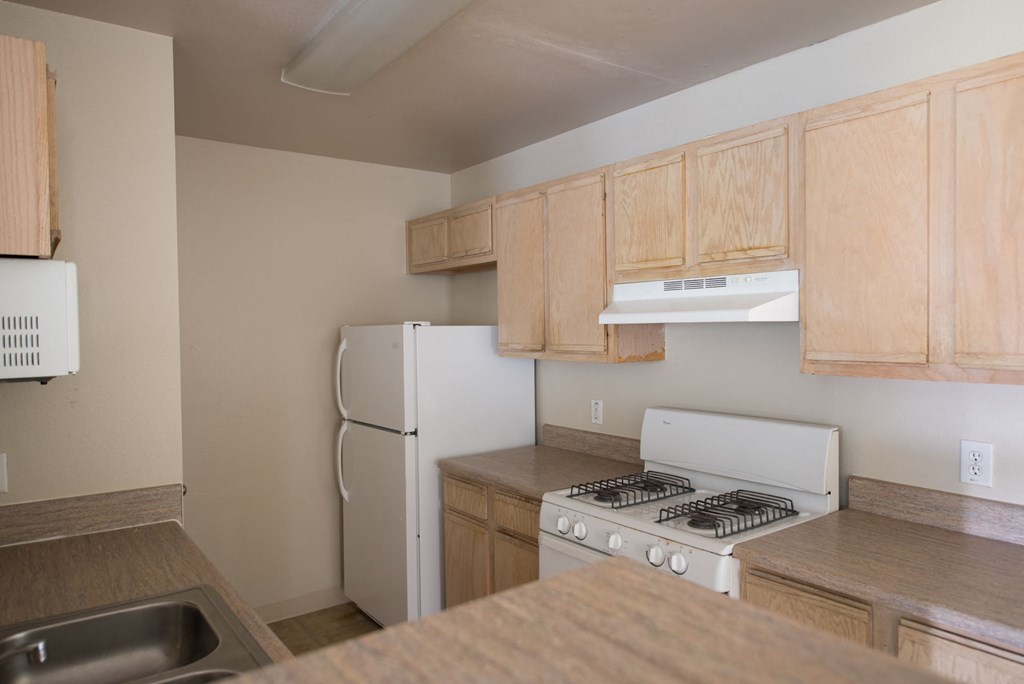 a kitchen with white appliances and wooden cabinets