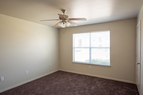 a bedroom with a ceiling fan and a window