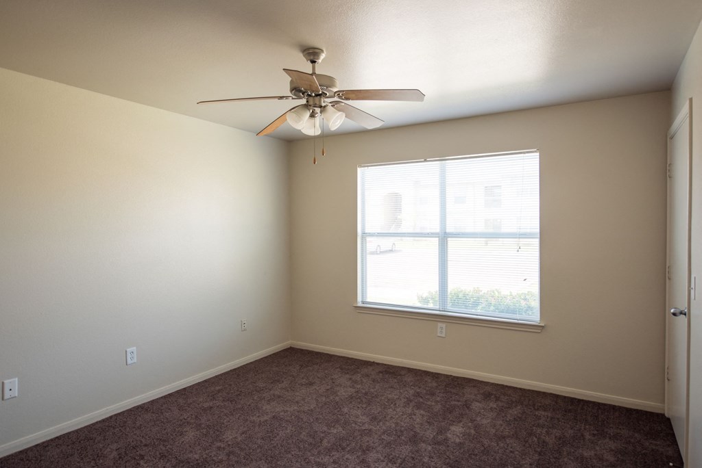 a bedroom with a ceiling fan and a window