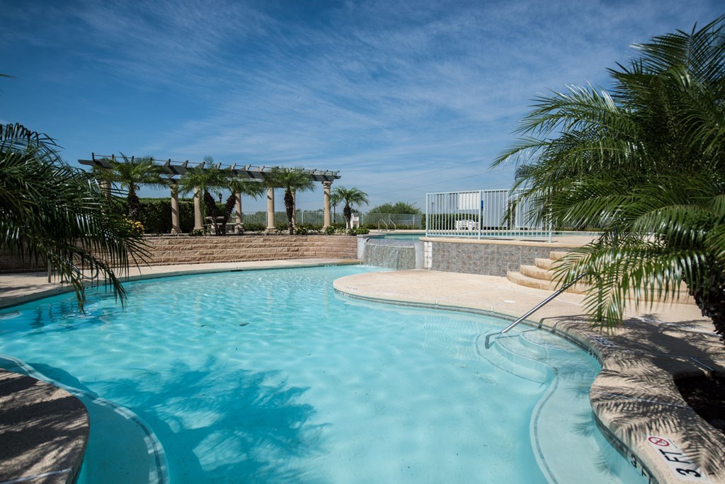 a large swimming pool with palm trees next to it