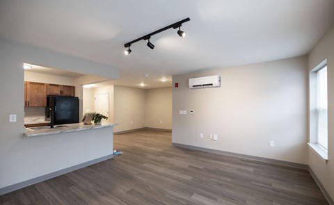 A spacious living room with a television and a window.