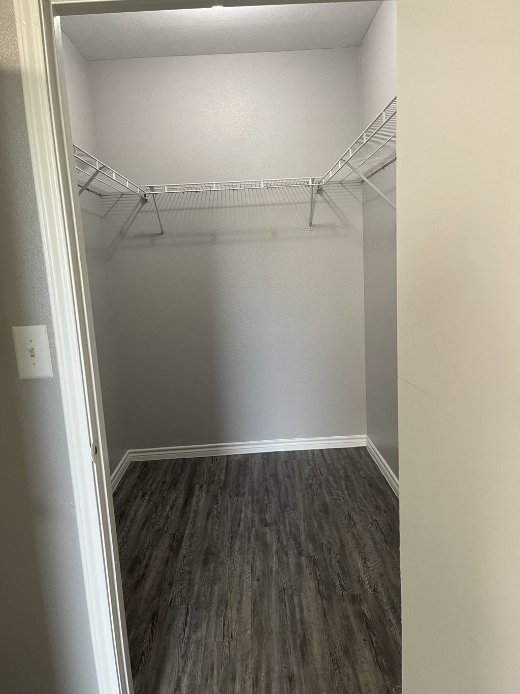 an empty room with wood flooring and a white closet