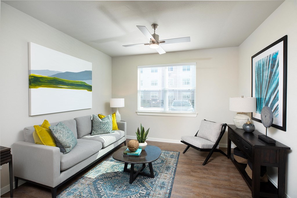 a living room with a couch chair and coffee table at 55 Fifty at Northwest Crossing, Houston, TX 77092