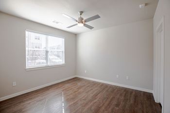 a bedroom with a ceiling fan and a window at 55 Fifty at Northwest Crossing, Texas