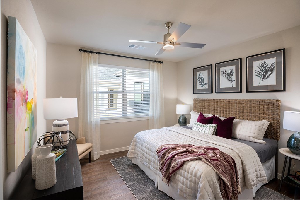 a bedroom with a large bed and a ceiling fan at 55 Fifty at Northwest Crossing, Houston, 77092