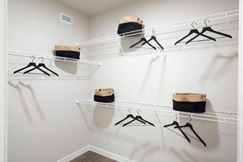 a spacious walk in closet in a bedroom plus den unit at 55 Fifty at Northwest Crossing, Houston Texas