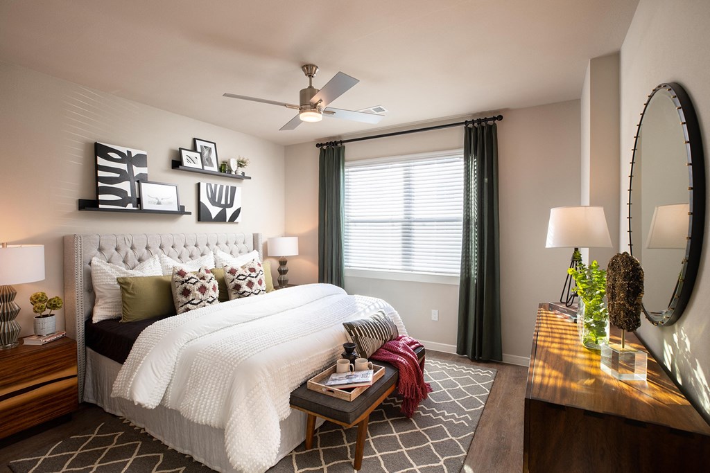 a bedroom with a large white bed and green curtains at 55 Fifty at Northwest Crossing, Houston, 77092