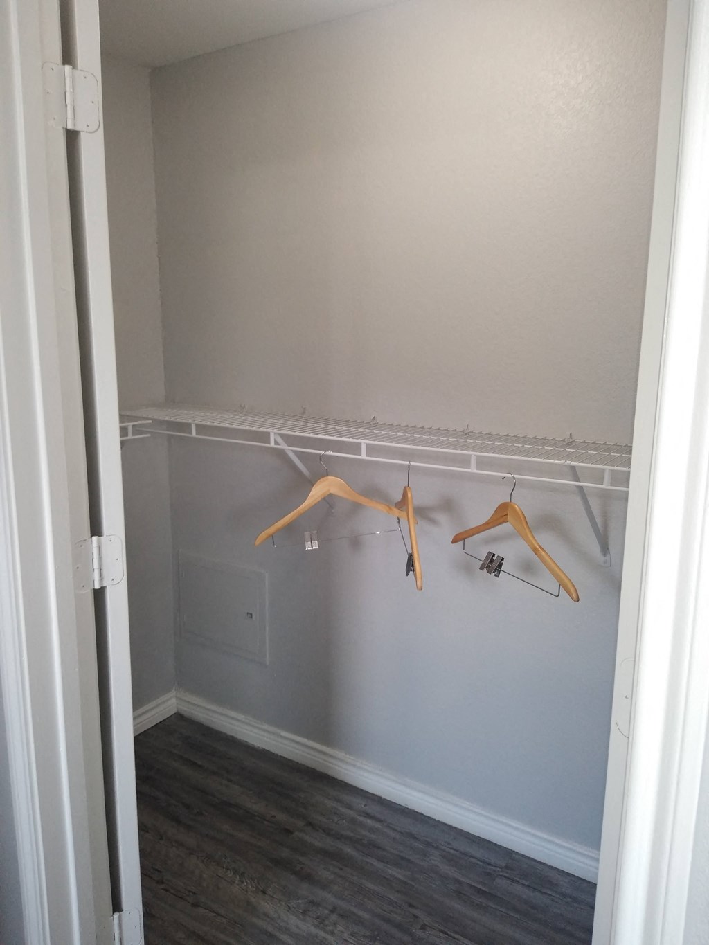 a closet with two clothes hangers in a white room