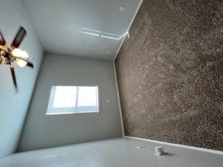 a room with a ceiling fan and a wall with a window