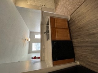 a small kitchen with an open door and a window