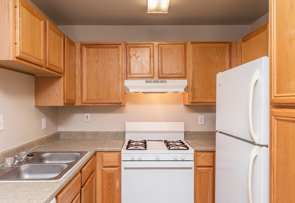 a kitchen with white appliances and wooden cabinets