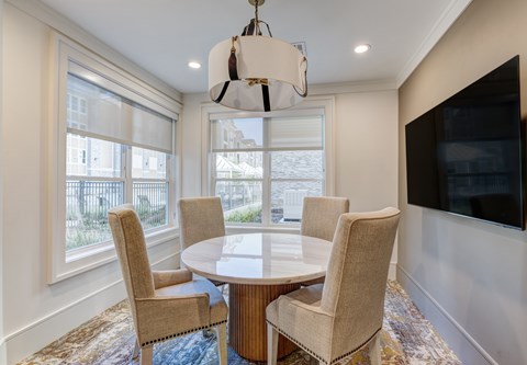 A dining room with a round table and chairs.