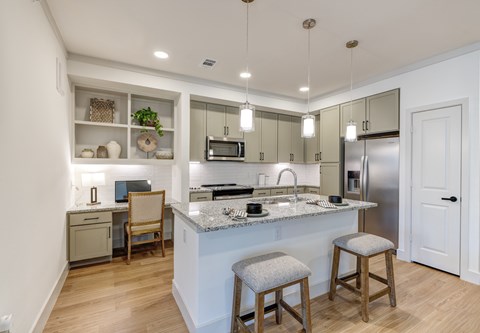 A kitchen with a white counter top and a sink.
