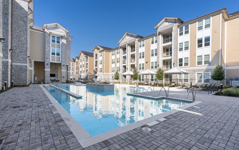 A large swimming pool surrounded by apartment buildings.