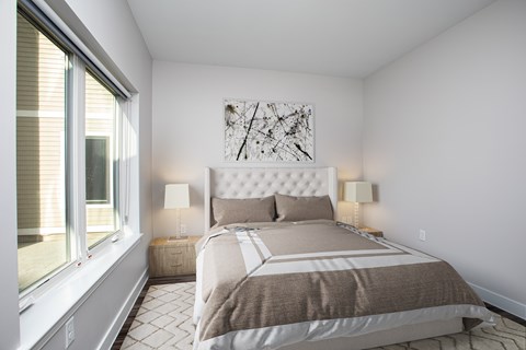 A bedroom with a large bed and a painting on the wall.