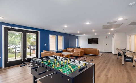Community game room with foosball and lounge seating at MLK Apartments, Hartford, CT