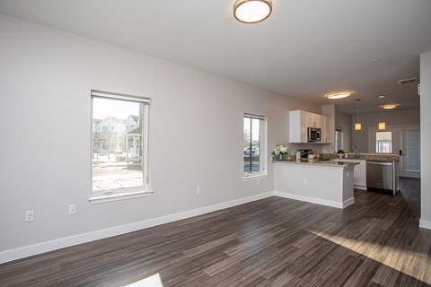 A kitchen with a white counter and brown flooring.