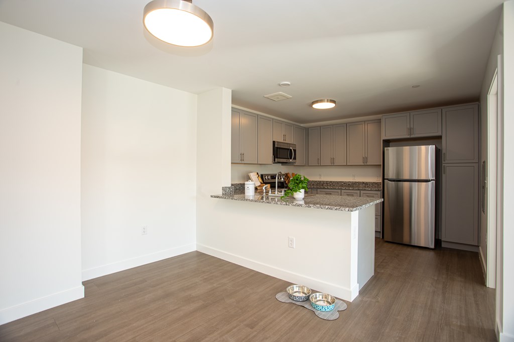A kitchen with a white counter and a stainless steel refrigerator.