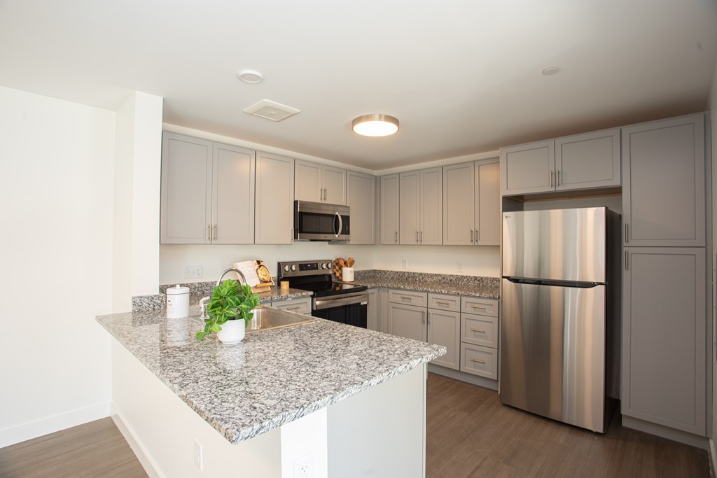 A kitchen with granite countertops and stainless steel appliances.