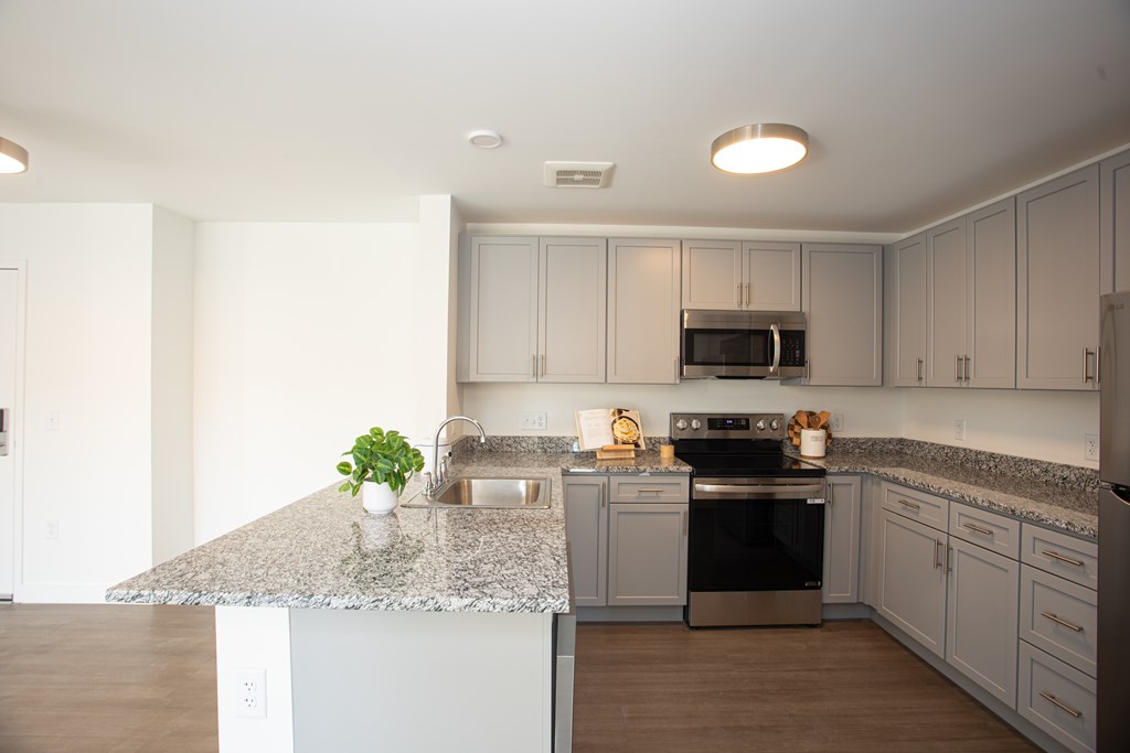 A kitchen with a granite countertop and stainless steel appliances.