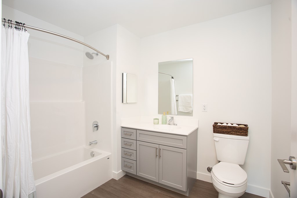 A white bathroom with a toilet, sink, and bathtub.