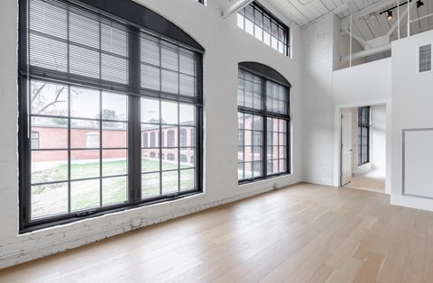 A large room with wooden floors and large windows.