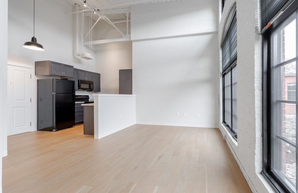 A kitchen area with a black refrigerator, microwave, and oven.