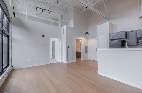 A large, empty room with wooden floors and white walls.