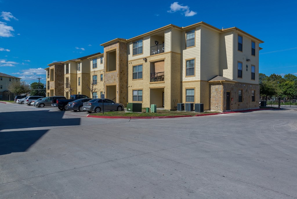 a large apartment building with cars parked in front of it